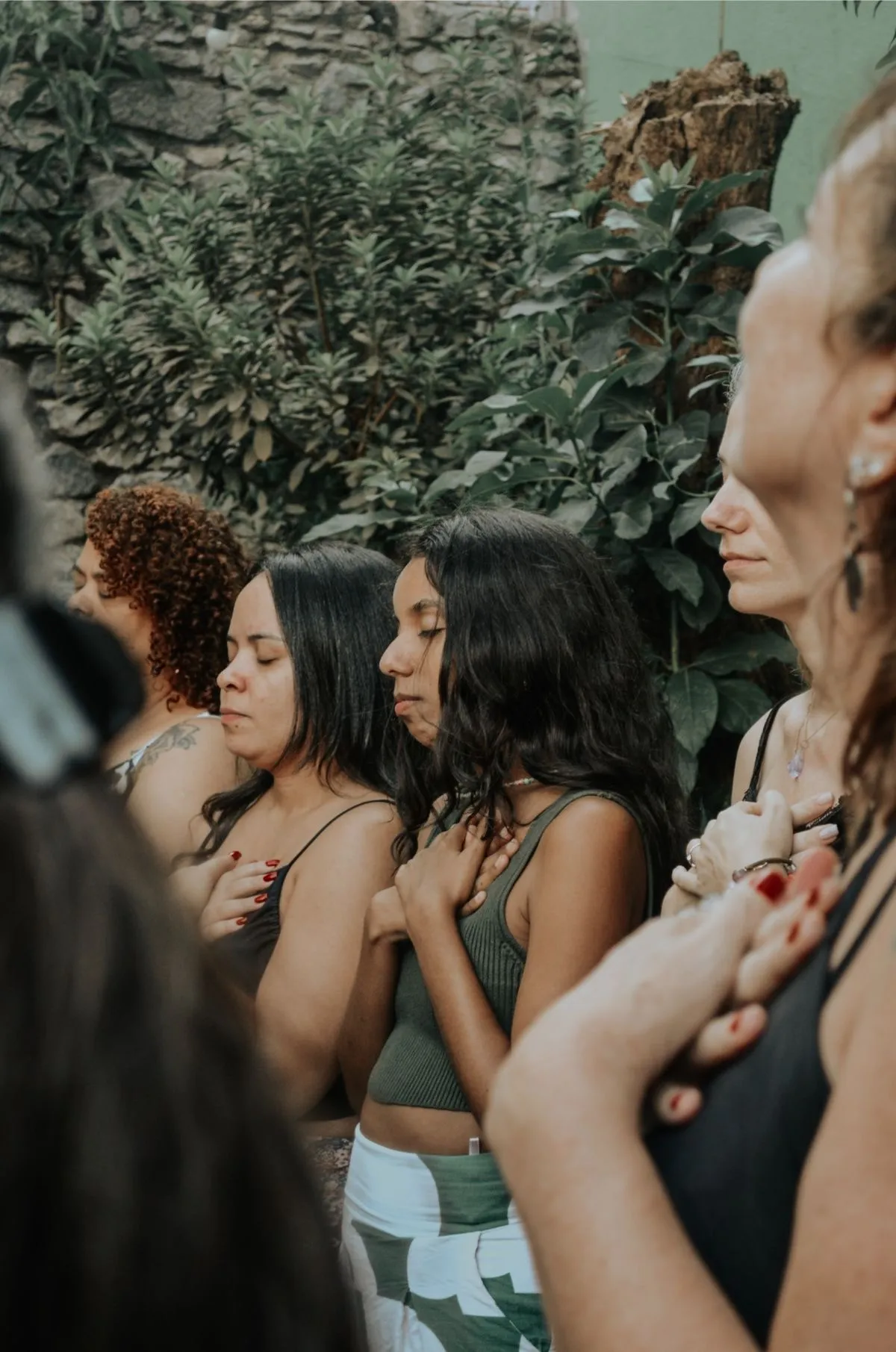 Mujeres en meditación con las manos sobre el corazón