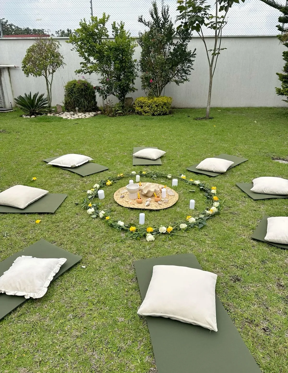 Círculo de meditación al aire libre con un mandala de flores en el centro