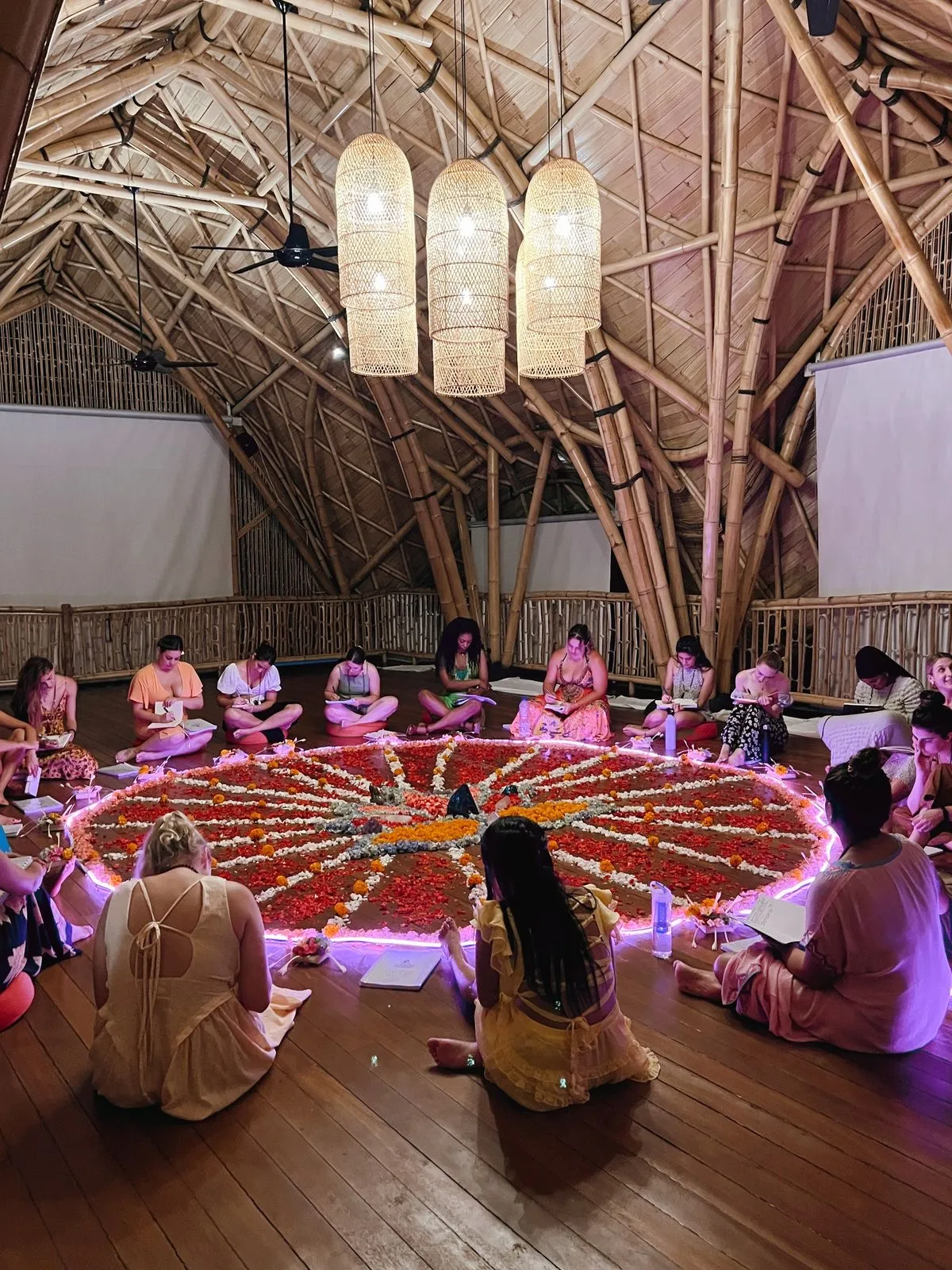 Grupo reunido alrededor de un mandala de flores durante un retiro espiritual